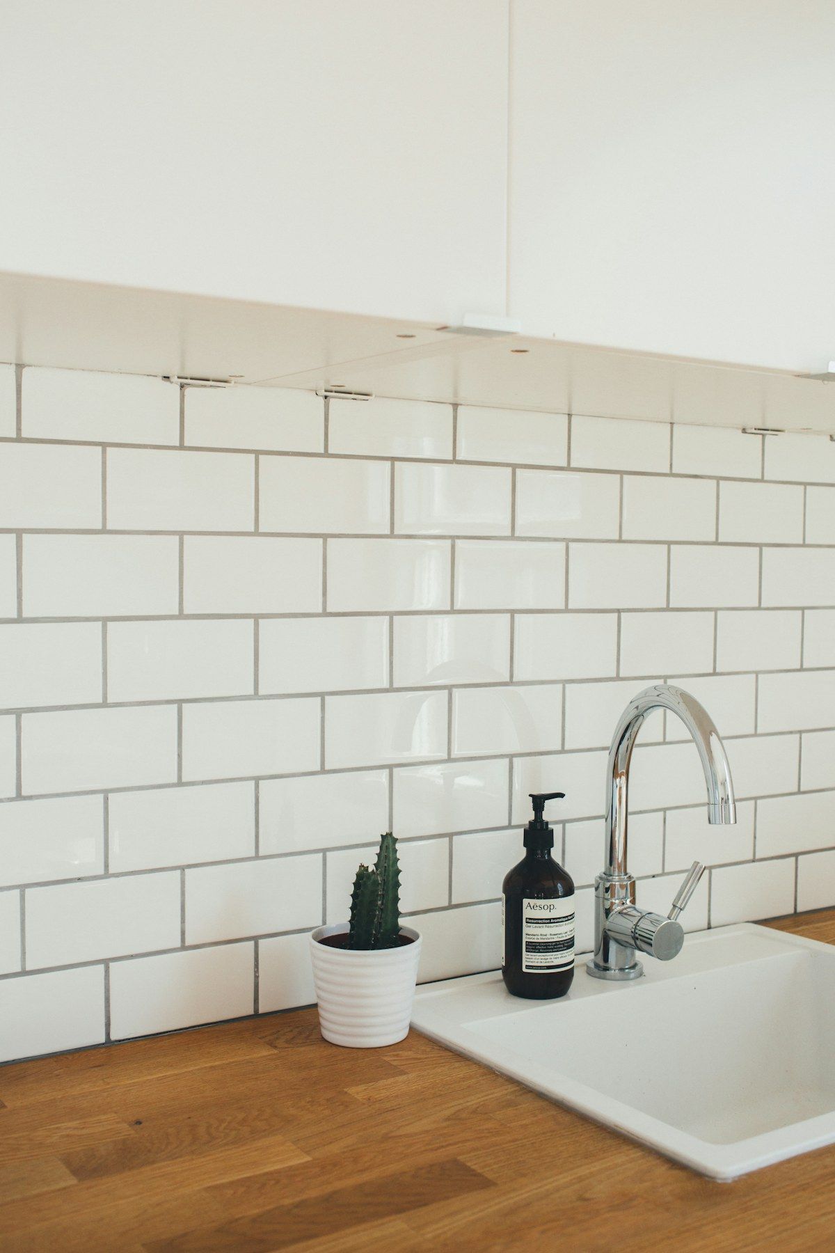 Muro de azulejo blanco con llave de agua